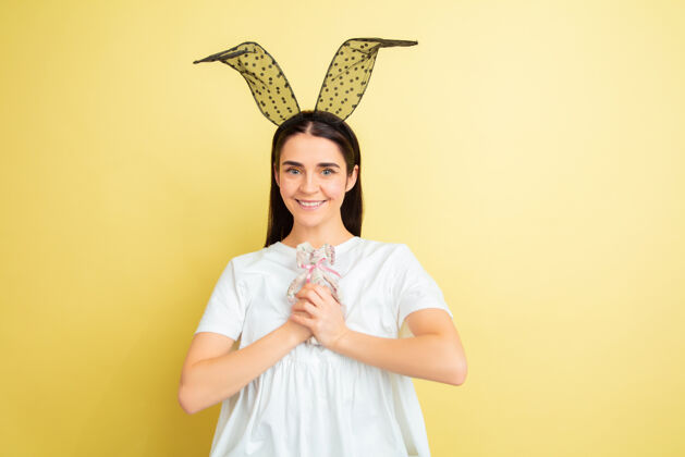 快乐黄色墙壁上的复活节兔女郎 情绪亮丽自信模特兔子