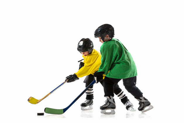 青少年冰球场和白墙上拿着棍子的小冰球运动员运动员们戴着设备和头盔练习运动的概念 健康的生活方式 运动 运动 动作动作棍棒比赛