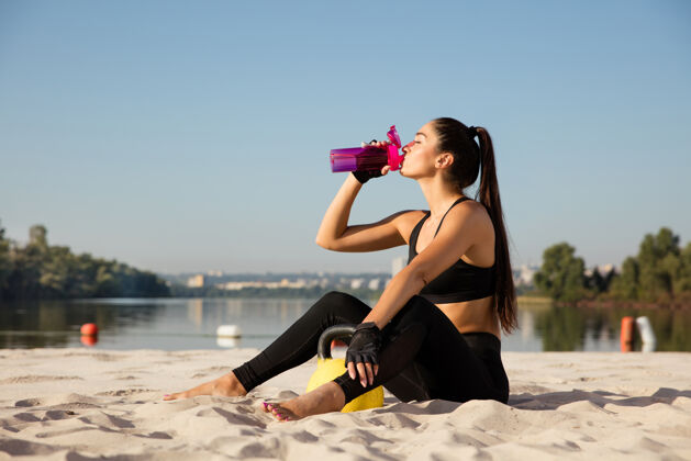 健康年轻健康的女子在沙滩上练习后休息运动练习身体