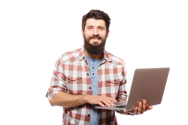 男士照片中 一个留着胡子的年轻人戴着眼镜 穿着衬衫 用笔记本电脑隔着白墙打字成人衬衫