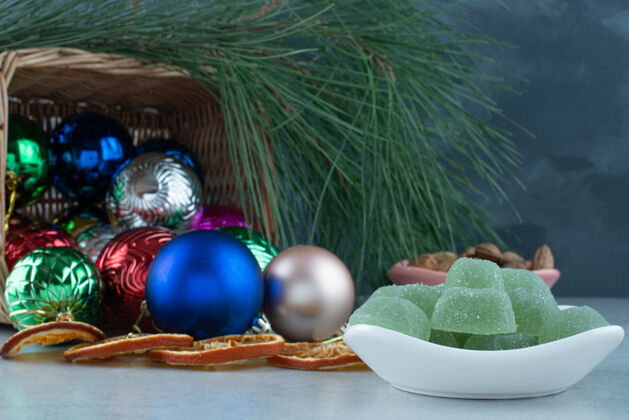 糖果圣诞喜庆球与白色盘子充满绿色果酱高品质的照片吃果冻果酱