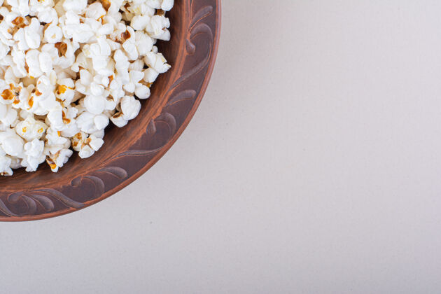 新鲜在白色背景上放一盘咸爆米花供电影之夜使用高质量照片松脆美味食物