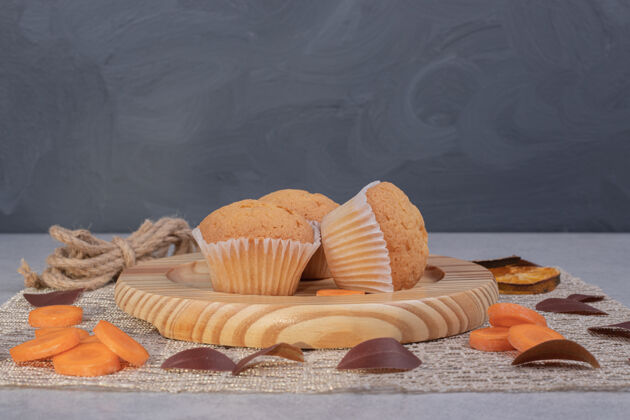 面包房松软的饼干 绳子和胡萝卜片放在大理石桌上高质量的照片毛绒糕点甜点