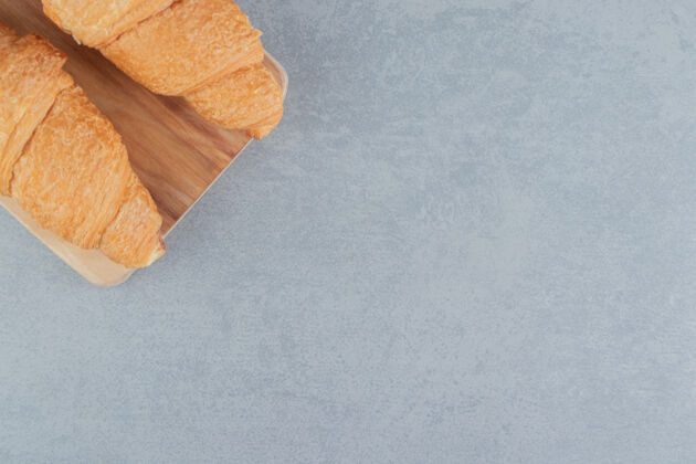 美味美味的羊角面包在木板上 大理石背景高品质的木板照片牙粉甜食配料
