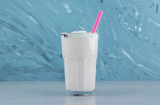甜味一杯美味的奶昔在大理石背景上高品质的照片爽口水果奶昔