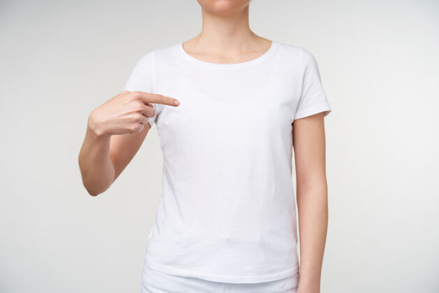 交流一张室内照片 一位穿着休闲服的年轻女士用食指指着一边 在聋哑语言上形成单词“i” 隔离在白色背景上非语言身体T恤