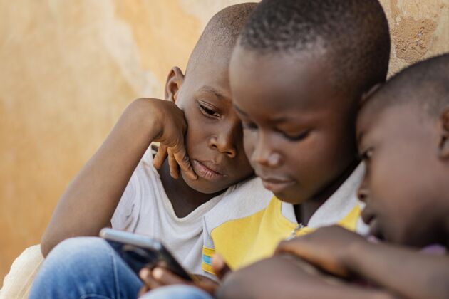 文化特写孩子们看智能手机农村非洲男孩