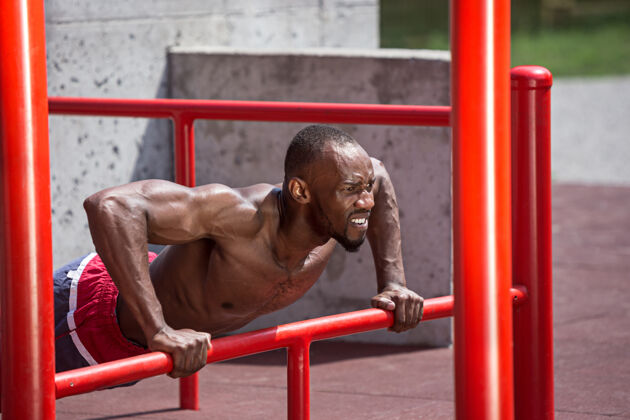 肌肉健身运动员在体育场做运动非裔或非裔美国男子在城市户外拉起体育锻炼健身 健康 生活方式的概念私人教练运动员人