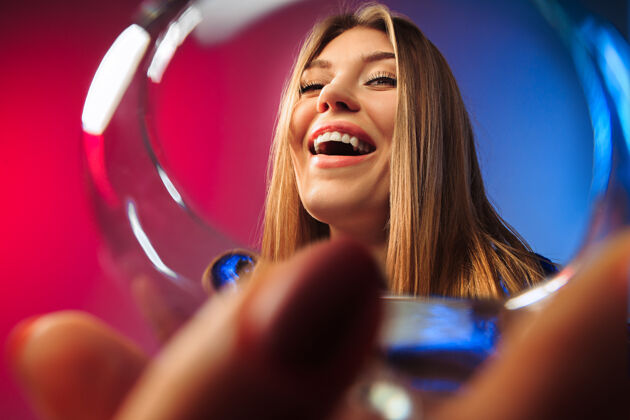 人穿着派对服的年轻女子拿着一杯酒摆出一副惊讶的姿势微笑酒精优雅