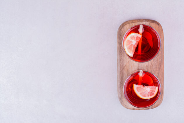 酒精在木板上放两杯红果汁柑橘酒吧极简