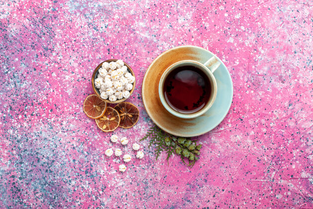 约束顶视图-一杯茶 粉色表面有白色的甜心咖啡设备糖果