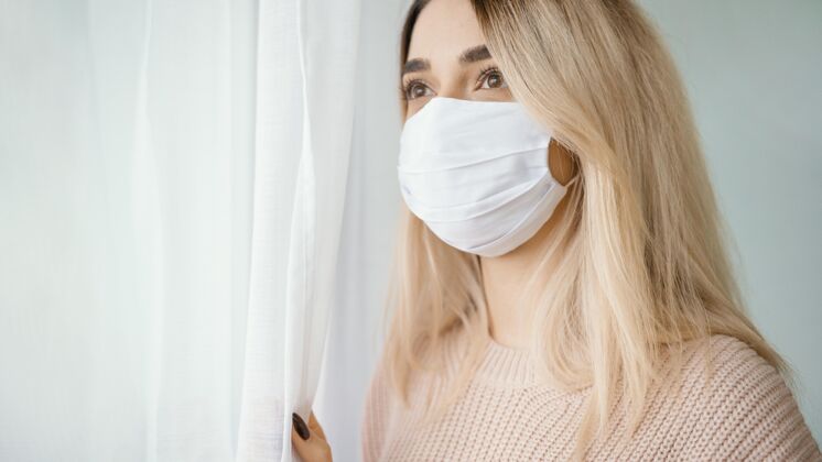 房子呆在室内戴白色医用口罩的女人限制流感疾病