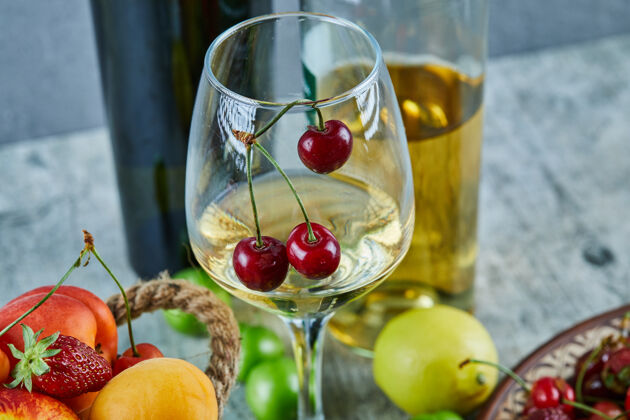 玻璃杯一桶夏天的水果 柠檬和一杯白葡萄酒放在大理石表面浆果樱桃水果
