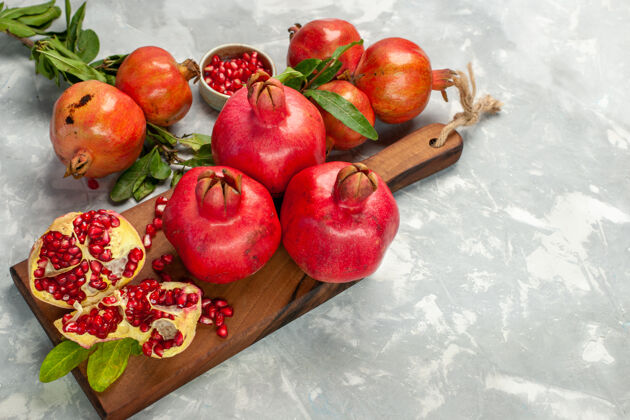 苹果半顶视图新鲜的红石榴 酸而醇厚的水果 浅白的桌子上的水果 新鲜醇厚的成熟的树清淡观赏可食用的水果