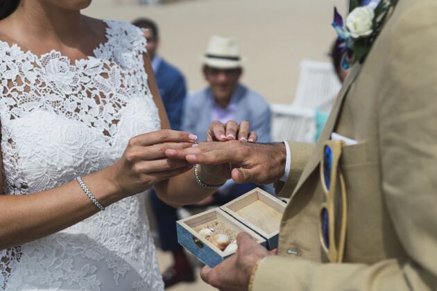 订婚一个新娘把结婚戒指戴在新郎手上的特写镜头珠宝新娘浪漫