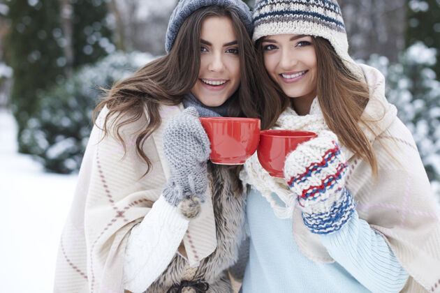 冻结年轻的朋友在冬天喝热饮手套户外帽子