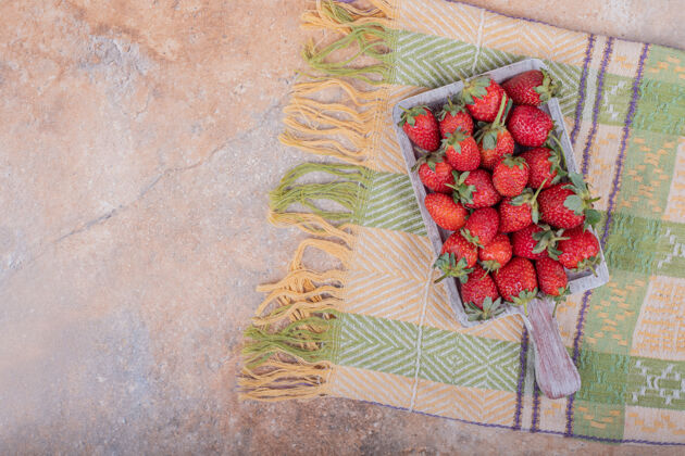 清淡红色草莓放在大理石上的乡村木盘里水果生物异国情调