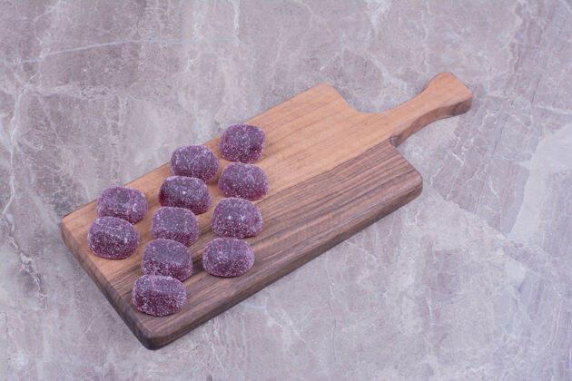 美味把紫色的果冻豆放在木盘上香草奶油极简