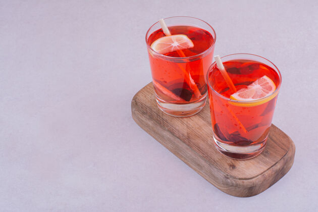 水在木板上放两杯红果汁新鲜饮料餐厅