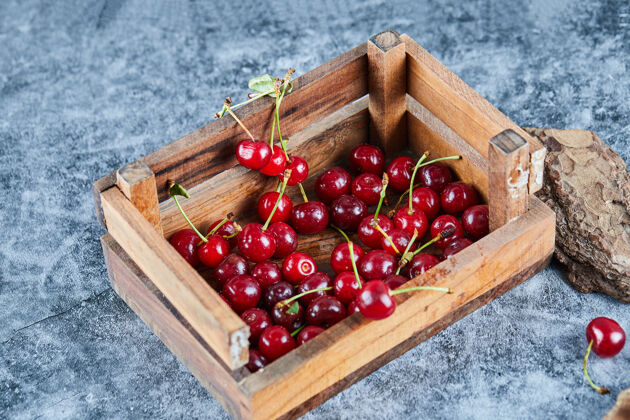 多汁红红的新鲜多汁的樱桃放在一个有叶子的木箱里堆叶子自然