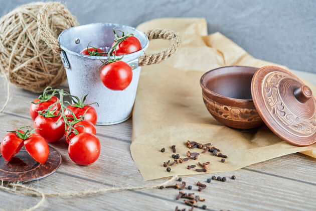番茄一桶西红柿和半切西红柿放在空碗的木桌上美味羊毛线