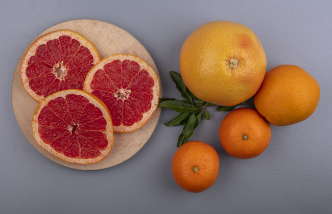水果俯瞰柚子片的立场与橙色的灰色背景立式切片顶部