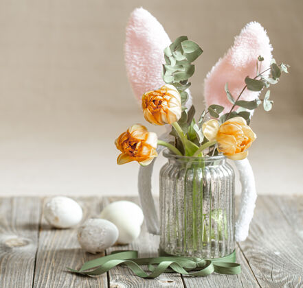 节日一束鲜花放在一个带有装饰元素的玻璃花瓶里复活节的概念构图花瓶装饰