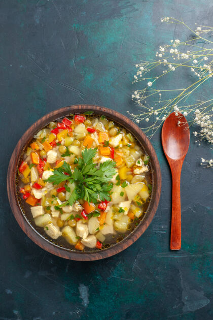 汤俯瞰美味的蔬菜汤 不同的配料在棕色的盘子里 在深色的桌子上 汤 蔬菜酱 食物 热菜盘子酱汁晚餐