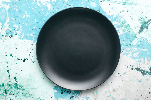 生的顶视图空圆形盘子深色蓝色背景色盘子厨房餐具玻璃盘子平底锅顶部