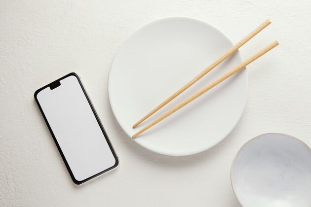 陶器顶视图安排优雅的餐具与智能手机移动的桌子组合的