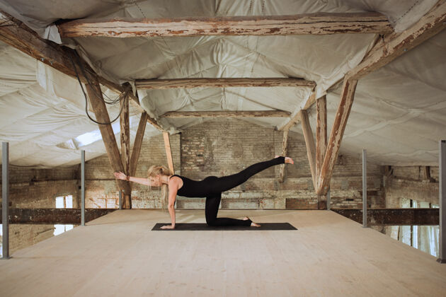 城市半月一位年轻的运动女性在废弃的建筑上练习瑜伽身心健康平衡健活方式的概念 运动 活动 减肥 专注女孩建筑女性