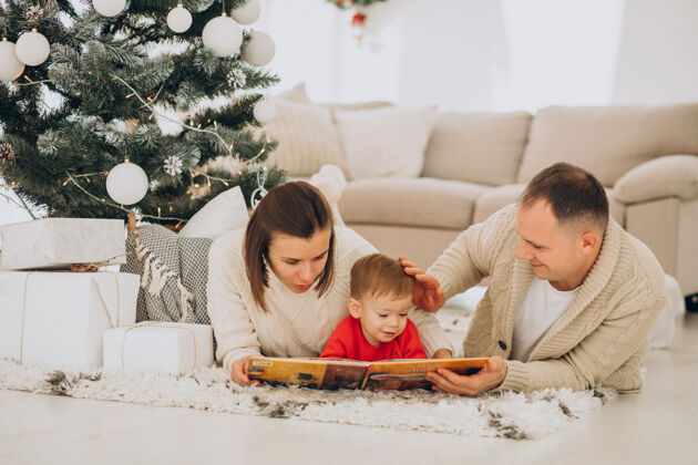 小一家人带着小儿子在家里的圣诞树旁过圣诞节儿子人圣诞树