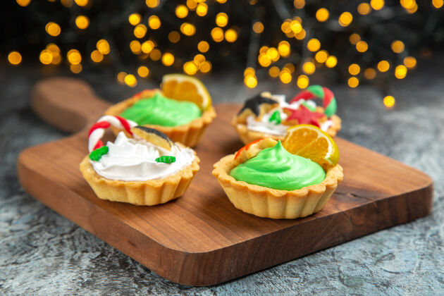盘子前视图小馅饼在砧板上黑暗的表面圣诞灯排骨面包房美食