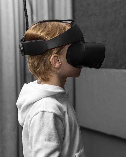 爱好侧视图的小男孩使用虚拟现实耳机青年男孩儿童