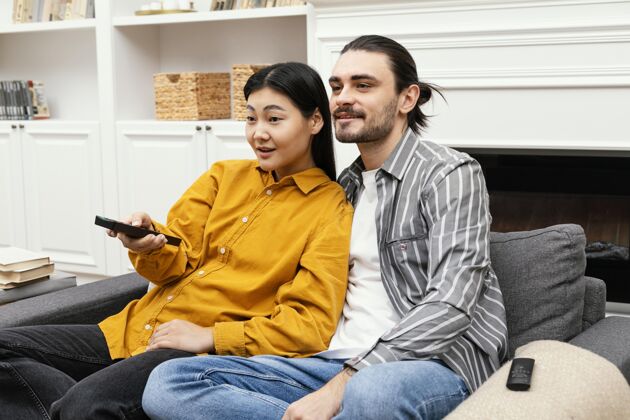 活动一对夫妇坐在沙发上看电视房子科技休闲时间
