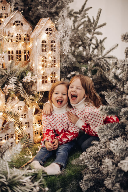 孩子们孩子们站在圣诞装饰的上层美丽圣诞毛衣