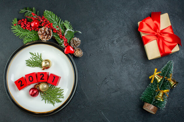 风景特写图上的数字装饰配件板冷杉树枝针叶树圆锥圣诞树上的黑色背景球果帽子午餐