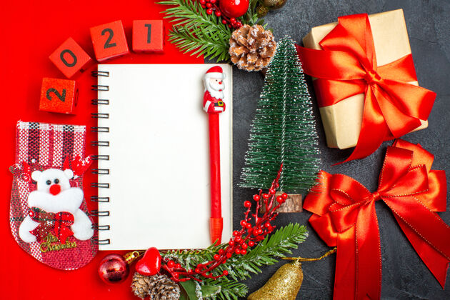 餐巾螺旋笔记本装饰配件的俯视图杉木枝xsmas袜子号码在红色餐巾纸和礼物圣诞树在黑暗的背景视图冬青袜子
