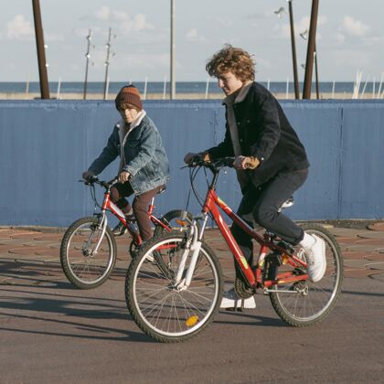 休闲户外骑自行车的儿童朋友侧视图年轻孩子青年