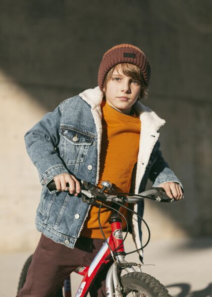 活动男孩在城市里和他的自行车在户外摆姿势户外娱乐自行车