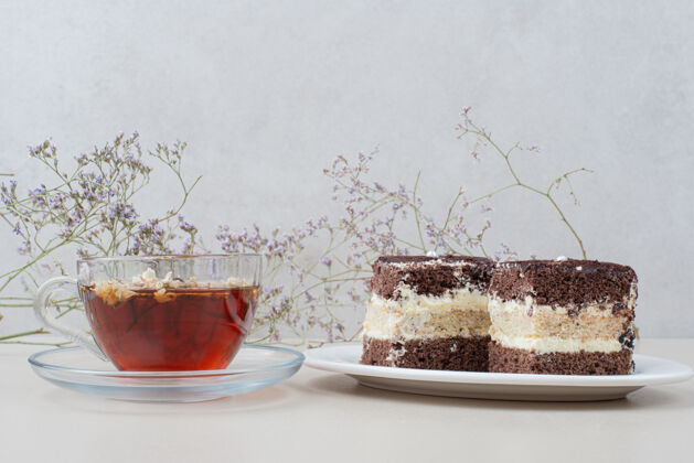 片两片提拉米苏蛋糕和一杯白茶玻璃植物面包房