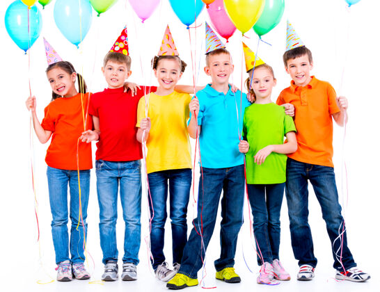 白种人一群快乐的孩子穿着彩色t恤 白色的墙上挂着气球青少年小微笑