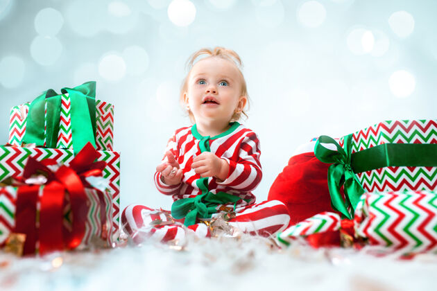 婴儿可爱的女婴 1岁 戴着圣诞帽 带着圣诞装饰 坐在地上玩圣诞球帽子房间小