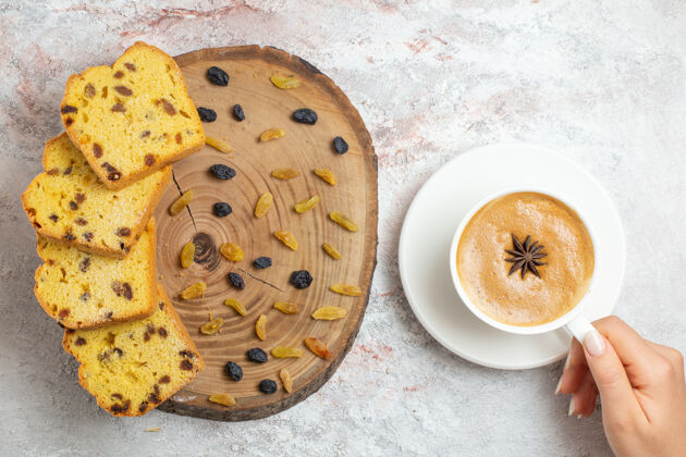 早餐俯瞰美味的蛋糕片与葡萄干和咖啡杯的白色背景饼干咖啡葡萄干