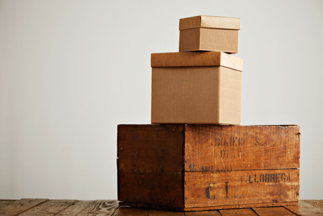 礼物不同大小和质地的棕色盒子排列成金字塔 放在一张纯朴的木桌上 白色的桌子上板条箱房子地板