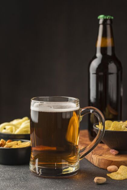醉酒啤酒品脱和啤酒瓶的正面图 以及各种小吃正面视图麦芽酒啤酒