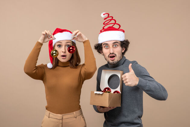 表演者喜庆的心情与兴奋可爱的夫妇戴着红色圣诞老人帽灰色肖像圣诞节节日