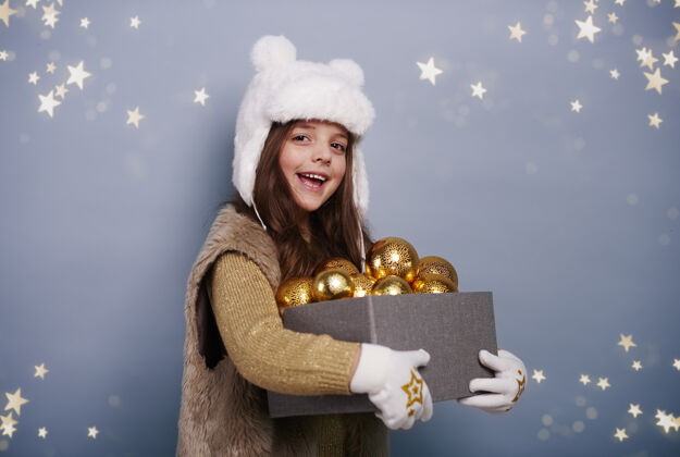 庆祝快乐的女孩拿着一盒圣诞球圣诞装饰装饰肖像