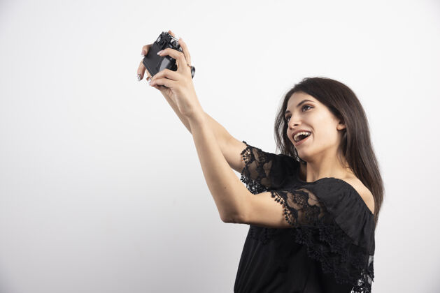 焦点黑发女人用相机自拍相机女性年轻