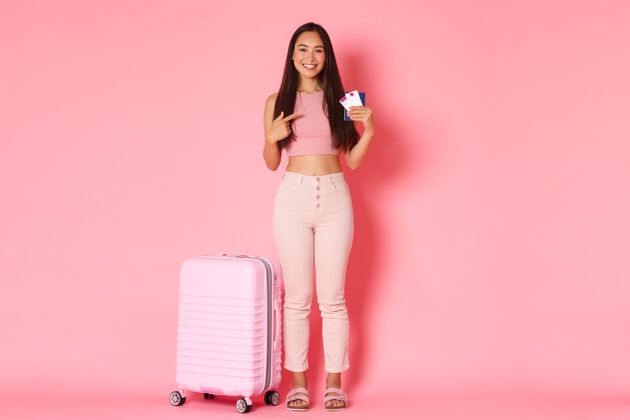 亚洲带着手提箱的年轻女子乐趣机票度假